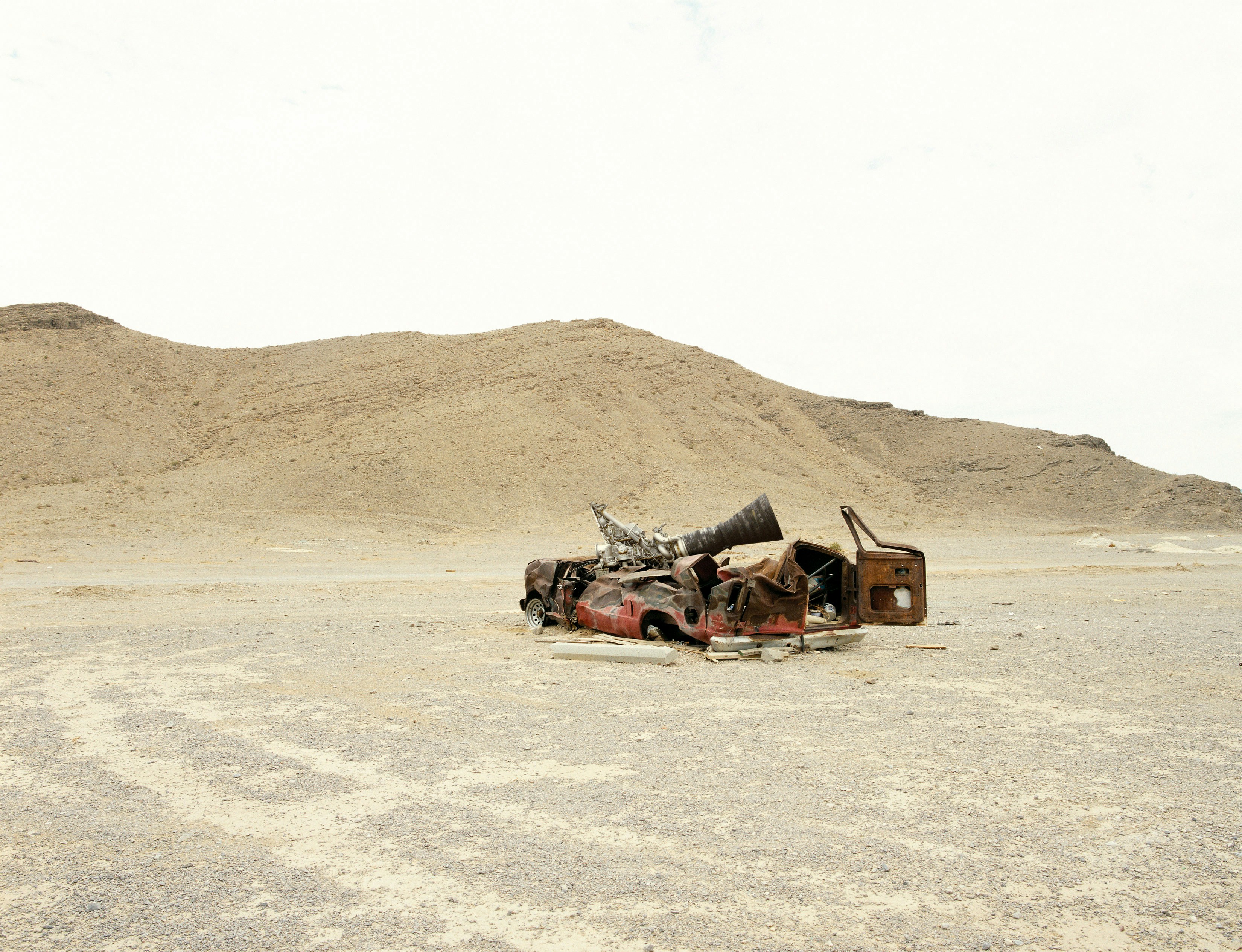 A rocket engine and a crashed car in a desert